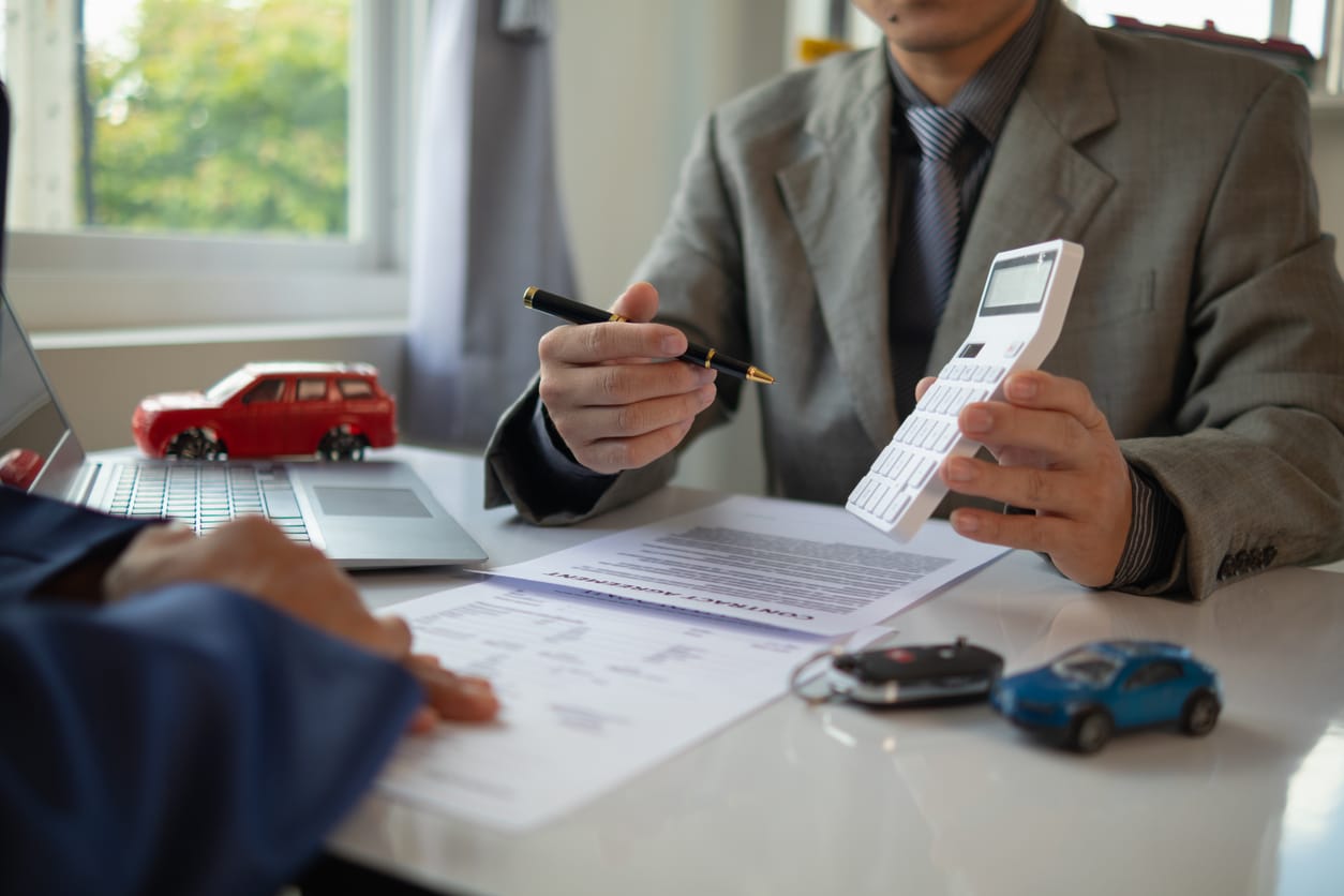 A Los Angeles homeowner reviewing EV tax credit and rebate paperwork with a car salesman.